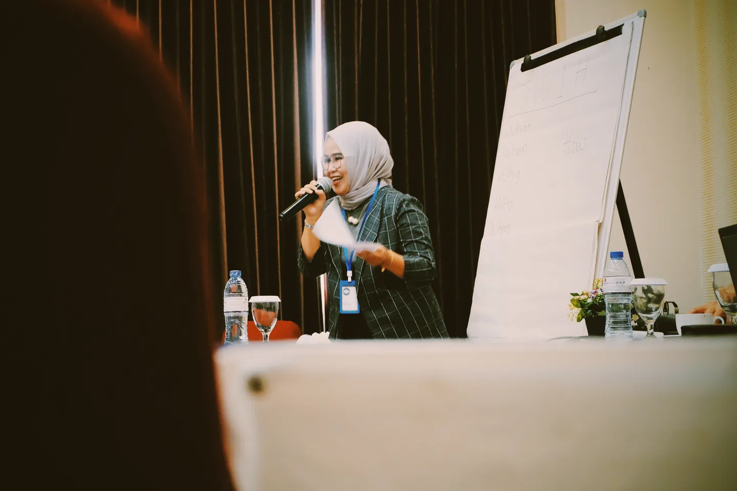 A woman presenting beside a flip chart at a business conference