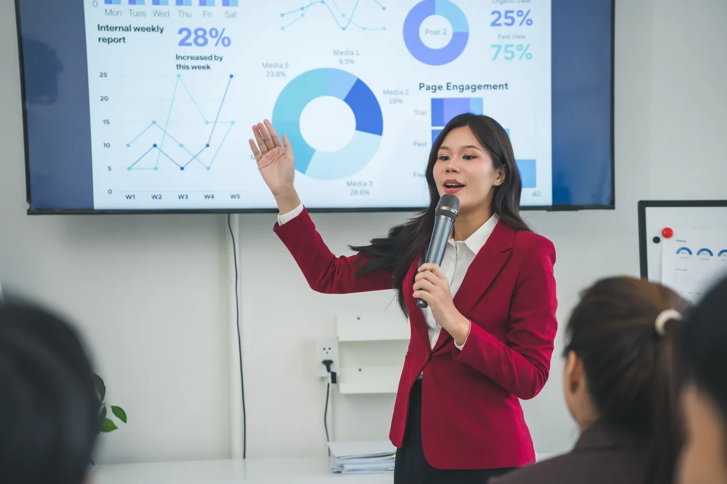 A presenter discussing business charts with colleagues