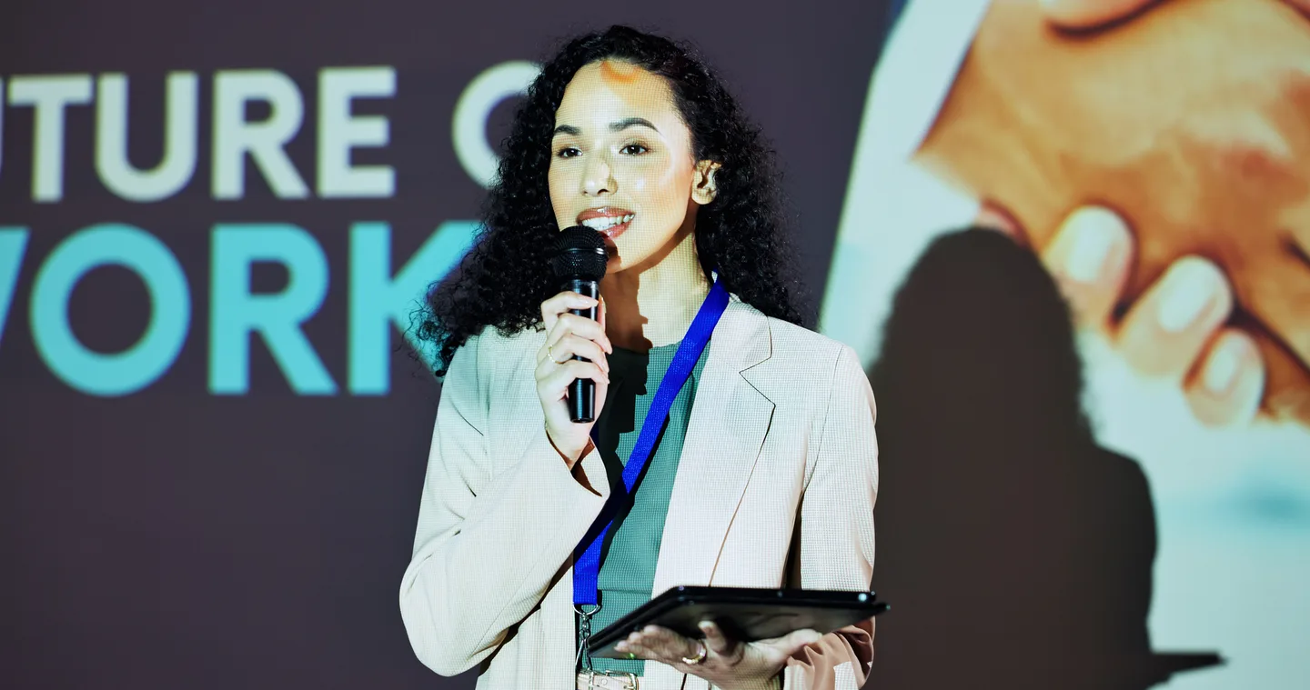 A presenter holding a tablet and discussing the future of work